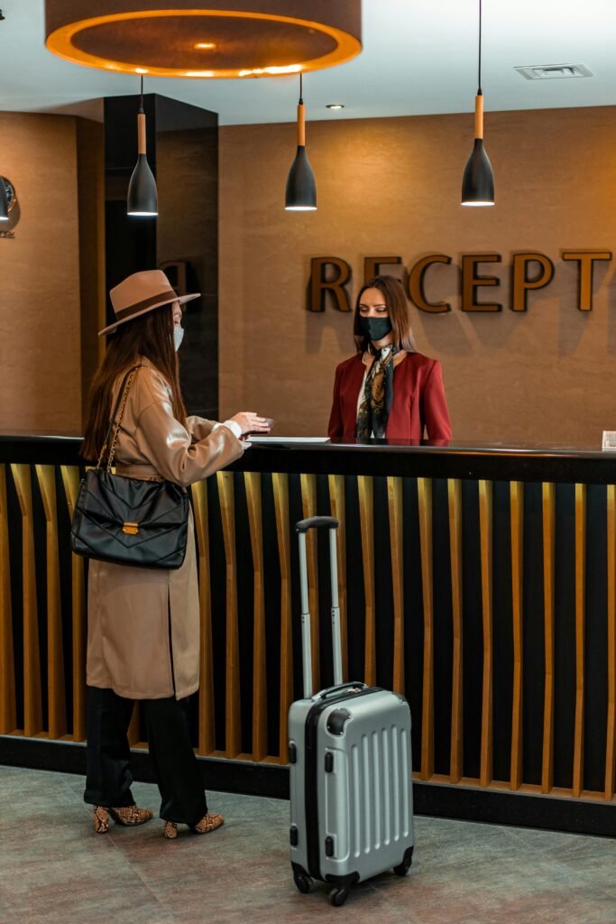 Businesswoman checking into a hotel at a stylish reception desk, engaging with staff.